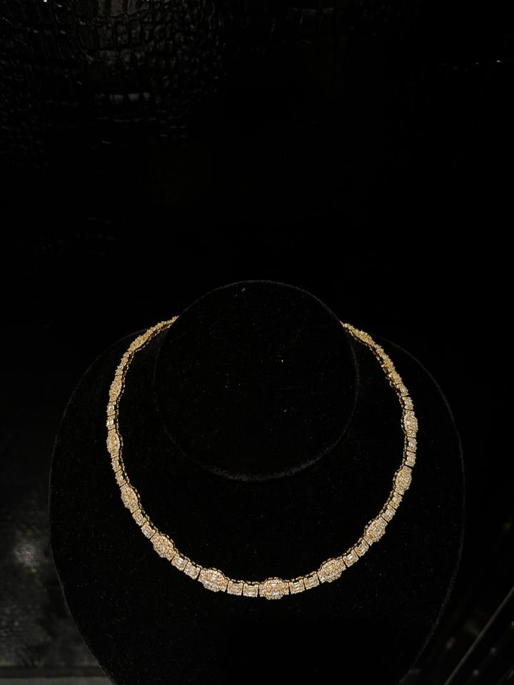 Collar de oro amarillo con racimos graduados de diamantes, colgado en un busto de terciopelo negro.